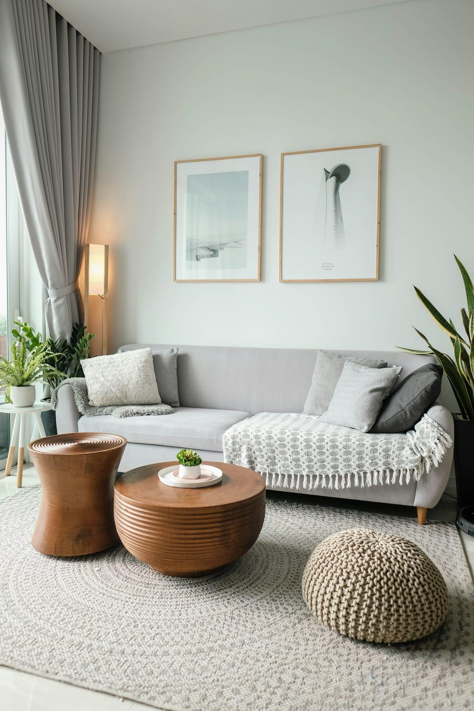 Light Scandinavian living room with grey sofa and round timber coffee tables